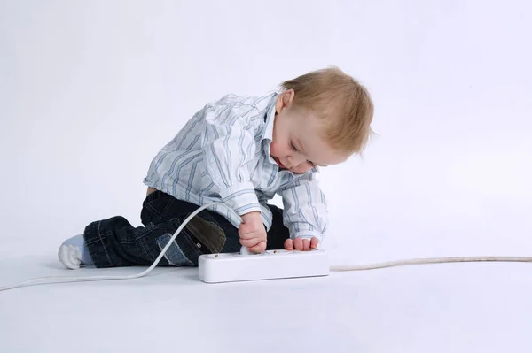 Little boy plays with plug — Stock Photo, Image