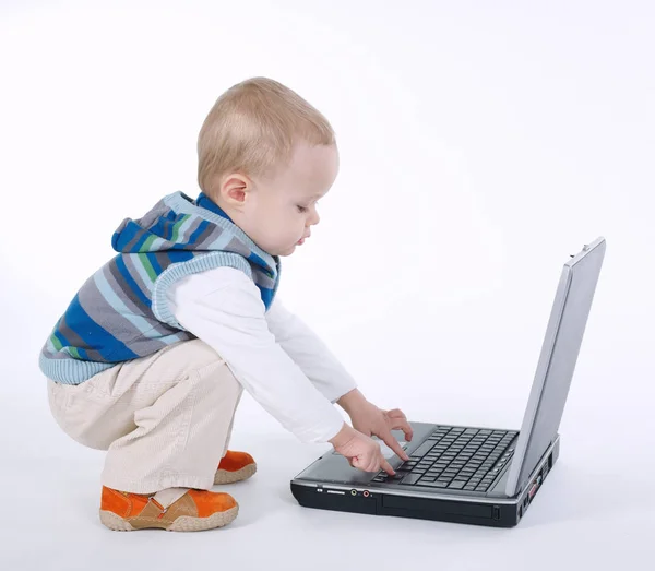 Schattige jongen met laptop op witte — Stockfoto