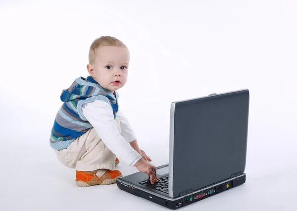 Симпатичный мальчик с ноутбуком на белом — стоковое фото