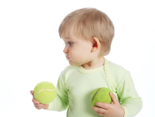 Söt liten flicka med tennisbollar — Stockfoto