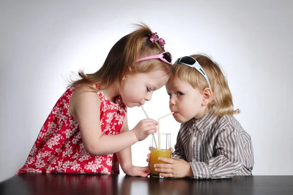 Boy and girl drinking juice — Stock Photo, Image
