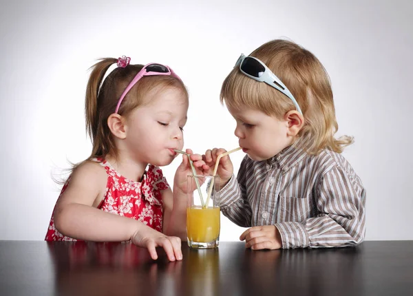 Menino e menina beber suco — Fotografia de Stock