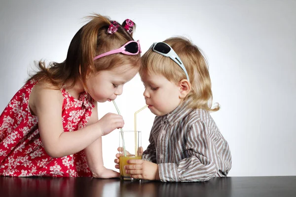 Boy and girl drinking juice — Stock Photo, Image