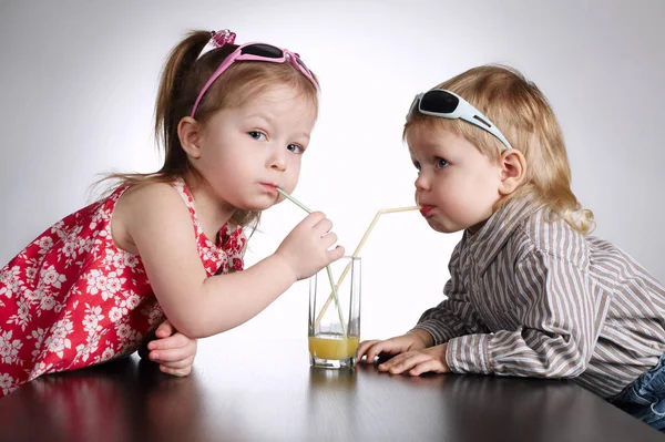 Menino e menina beber suco — Fotografia de Stock