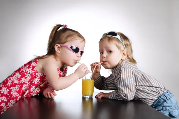 Menino e menina beber suco — Fotografia de Stock