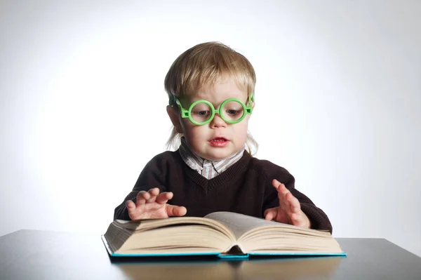 Chlapec v legrační brýle čtení knihy na bílém — Stock fotografie