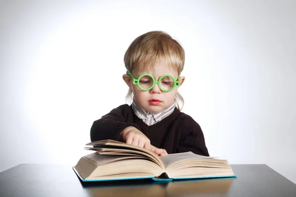 Garçon dans des lunettes drôles livre de lecture sur blanc — Photo