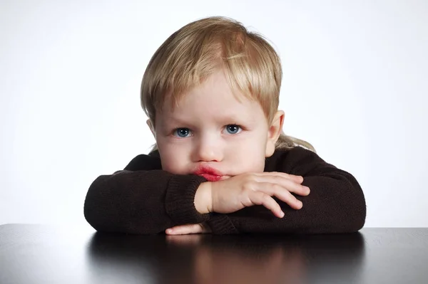 Schattig verveeld beetje jongen op witte achtergrond — Stockfoto