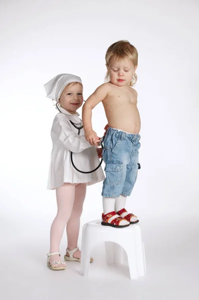 Menino e menina jogando médico no branco — Fotografia de Stock