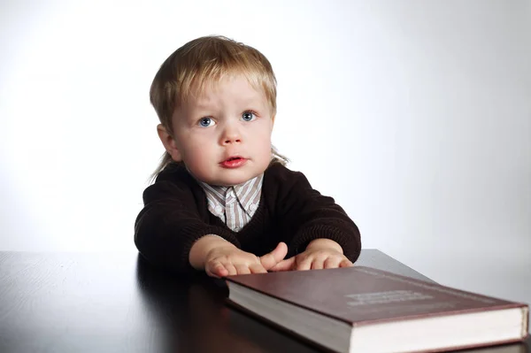 Junge liest Buch auf Weiß — Stockfoto