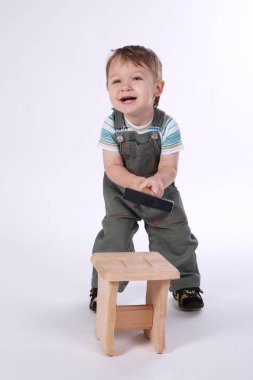 çekiç ve ahşap sandalye ile küçük çocuk