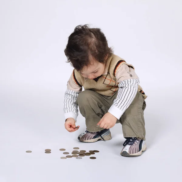 Lindo niño juega con monedas —  Fotos de Stock