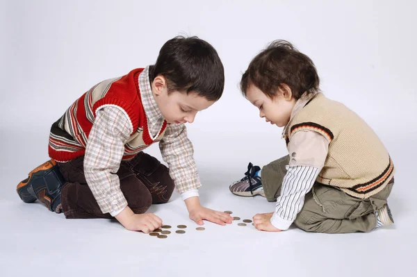 Bonito menino brinca com moedas — Fotografia de Stock