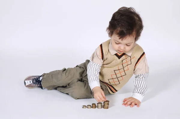 Söt liten pojke leker med mynt — Stockfoto