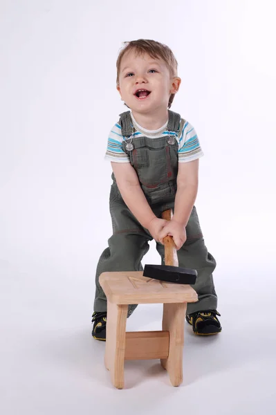 Kleiner Junge mit Hammer und Holzstuhl — Stockfoto