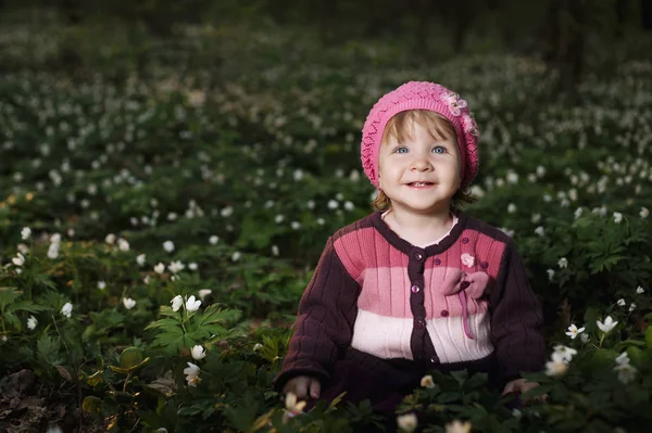 Beautiful little girl in forest on flowers field — Stock Photo, Image