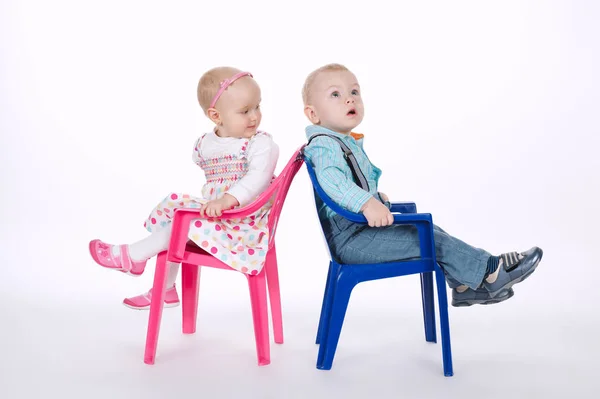 Divertido chico y chica sentado en sillas espalda con espalda — Foto de Stock