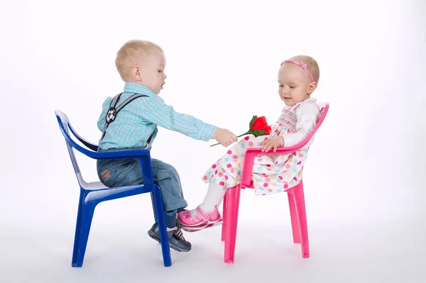 Funny boy and girl sitting on chairs on white — Stock Photo, Image