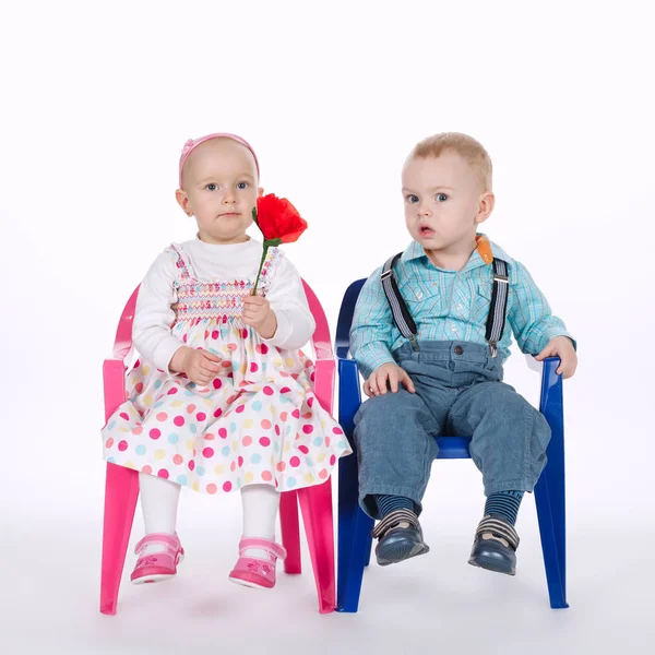 Engraçado menino e menina sentado em cadeiras no branco — Fotografia de Stock