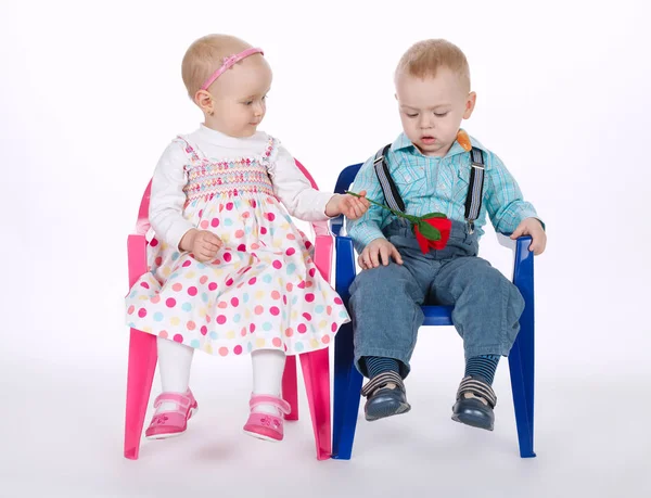 Funny boy and girl sitting on chairs on white — Stock Photo, Image