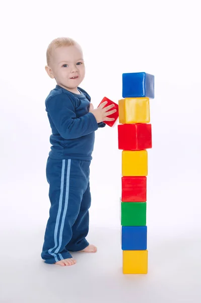 Boy plays with cubes on white — Stock Photo, Image