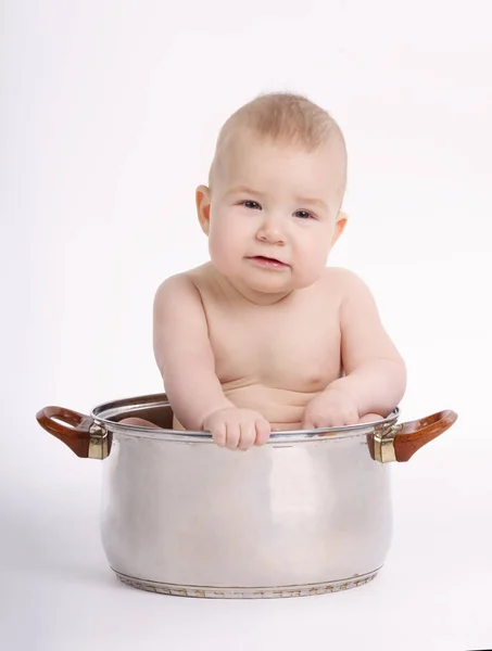 Pequeño chico divertido sentado en la sartén —  Fotos de Stock