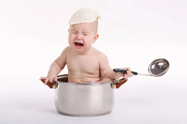 Маленький смішний хлопчик сидить на сковороді — стокове фото