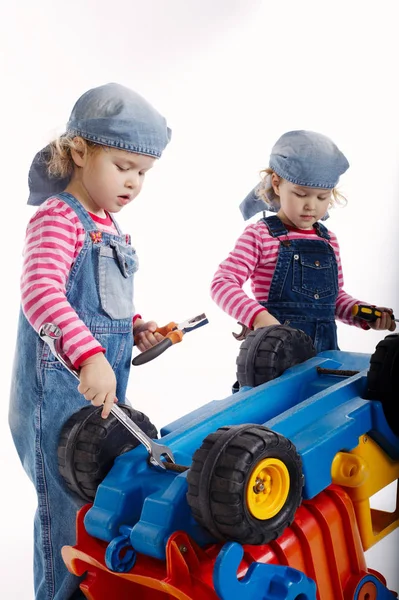 Cute little twin girls repairing car — Stock Photo, Image