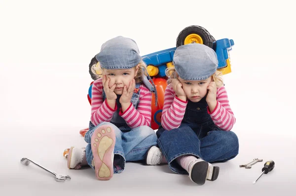 Cute little twin girls repairing car — Stock Photo, Image