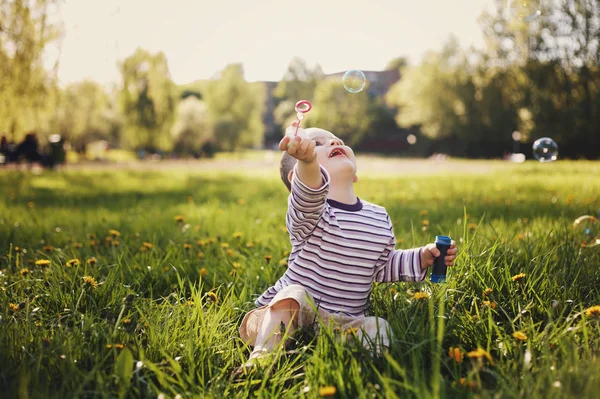 Αγόρι παίζει με φυσαλίδες στο πάρκο καλοκαίρι — Φωτογραφία Αρχείου