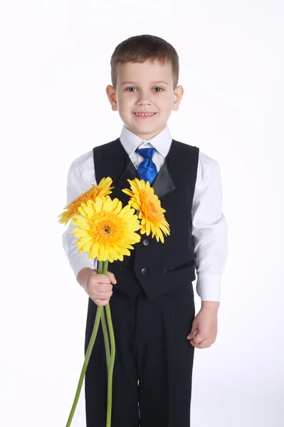 Menino feliz com flores amarelas — Fotografia de Stock