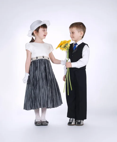 Niño y niña con flores en la fecha —  Fotos de Stock