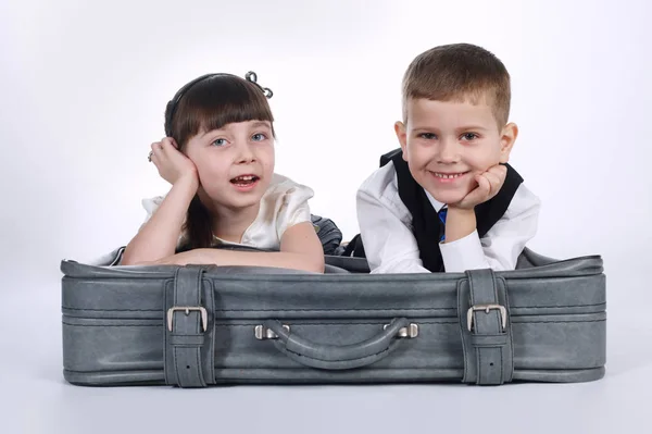 Junge und Mädchen liegen auf Koffer — Stockfoto