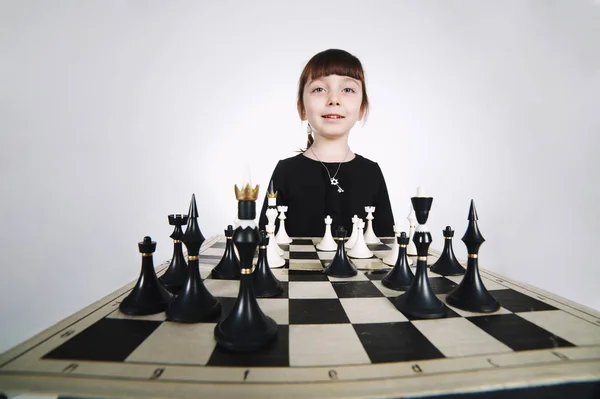 Little girl playing chess on white — Stock Photo, Image