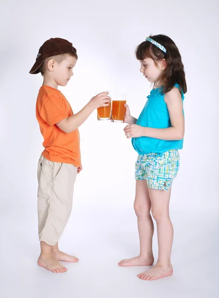 Menino e menina bebendo suco — Fotografia de Stock
