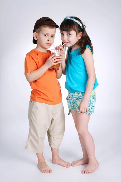 Menino e menina bebendo suco — Fotografia de Stock