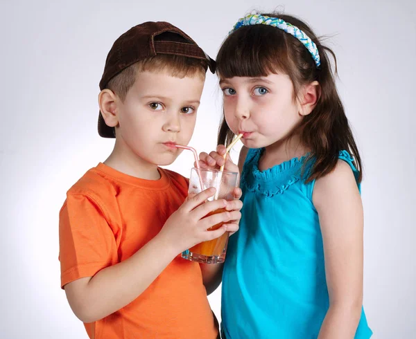 Bambino e ragazza bere succo — Foto Stock