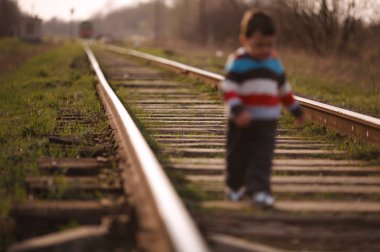 küçük güzel çocuk demiryolu üzerinde çalış