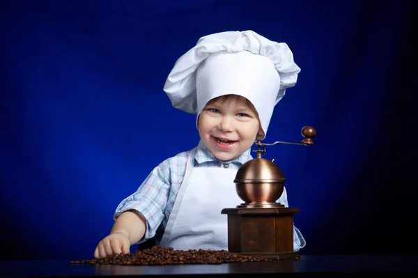 Маленький мальчик играет с кофейной мельницей — стоковое фото