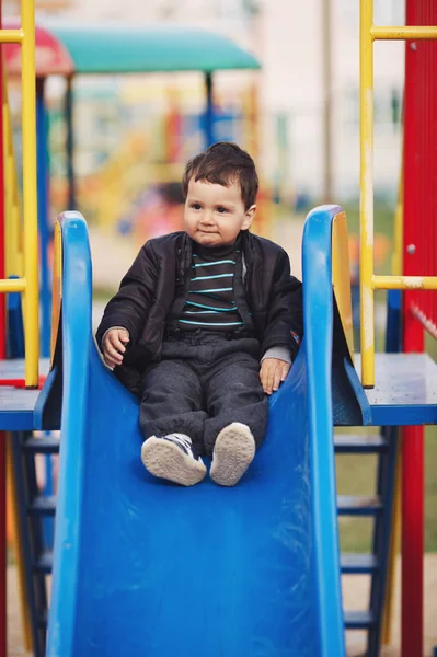 Little boy playing on slide — Stock Photo, Image