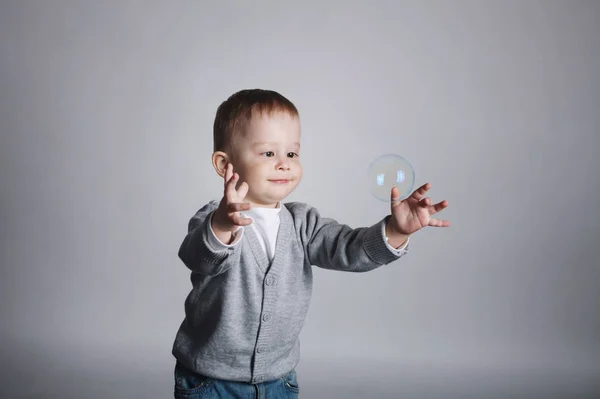 Little funny boy plays with bubbles — Stock Photo, Image