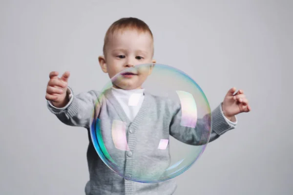 Pequeño divertido chico juega con burbujas — Foto de Stock