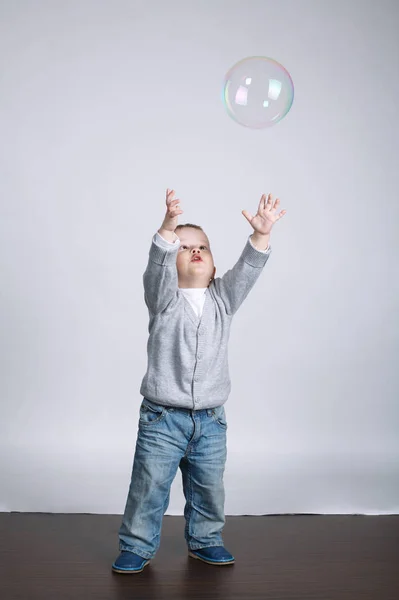 Pequeno engraçado menino joga com bolhas — Fotografia de Stock