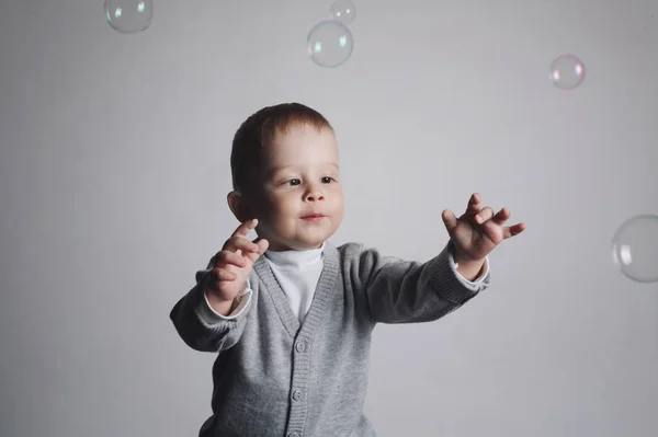 Little funny boy plays with bubbles Stock Photo