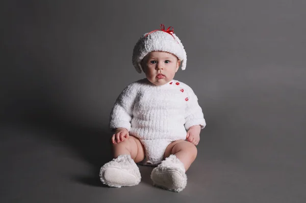 Hermoso bebé en un vestido de punto y gorra —  Fotos de Stock