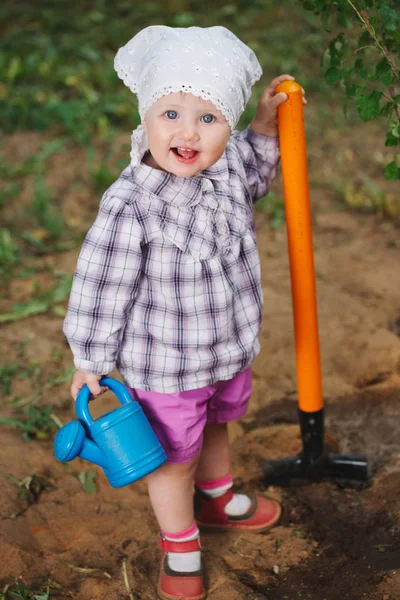 Pequeño niño divertido con pala en el jardín —  Fotos de Stock