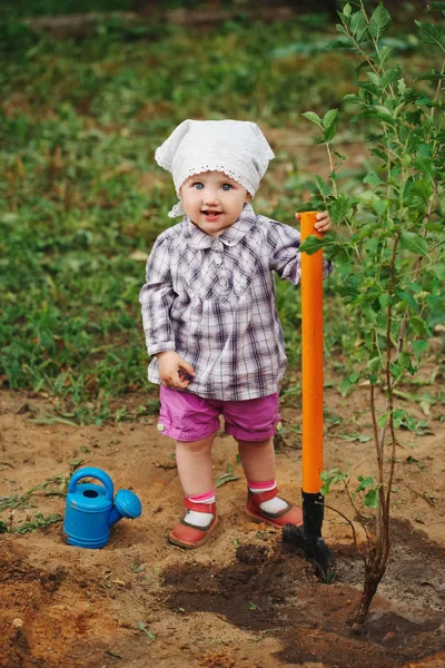 little funny boy with shovel in garden