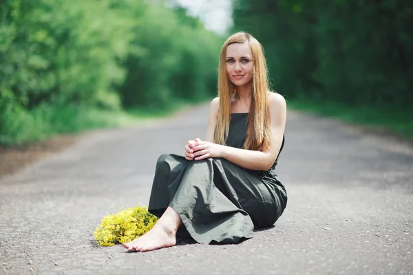 Mooi blond meisje op de weg — Stockfoto