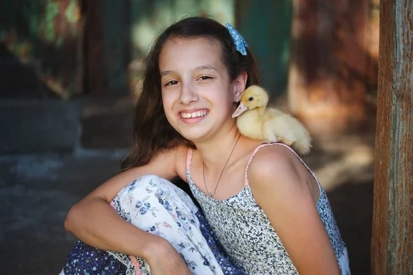 Girl with little yellow duckling in summer village — Stock Photo, Image
