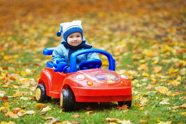 Pequeno engraçado menino condução brinquedo carro — Fotografia de Stock